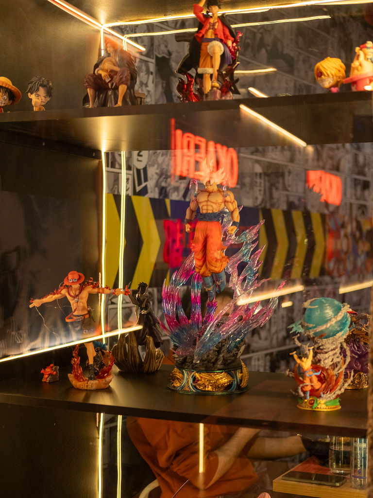 A lit cabinet holding anime figures across several shelves